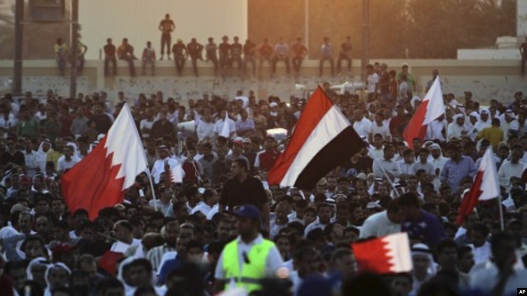 Supporters of the Shiite opposition Al-Wefaq society wave red-and-white Bahraini flags and a Yemeni flag during a rally in Tubli, Bahrain, near the capital of Manama, September 22, 2011.