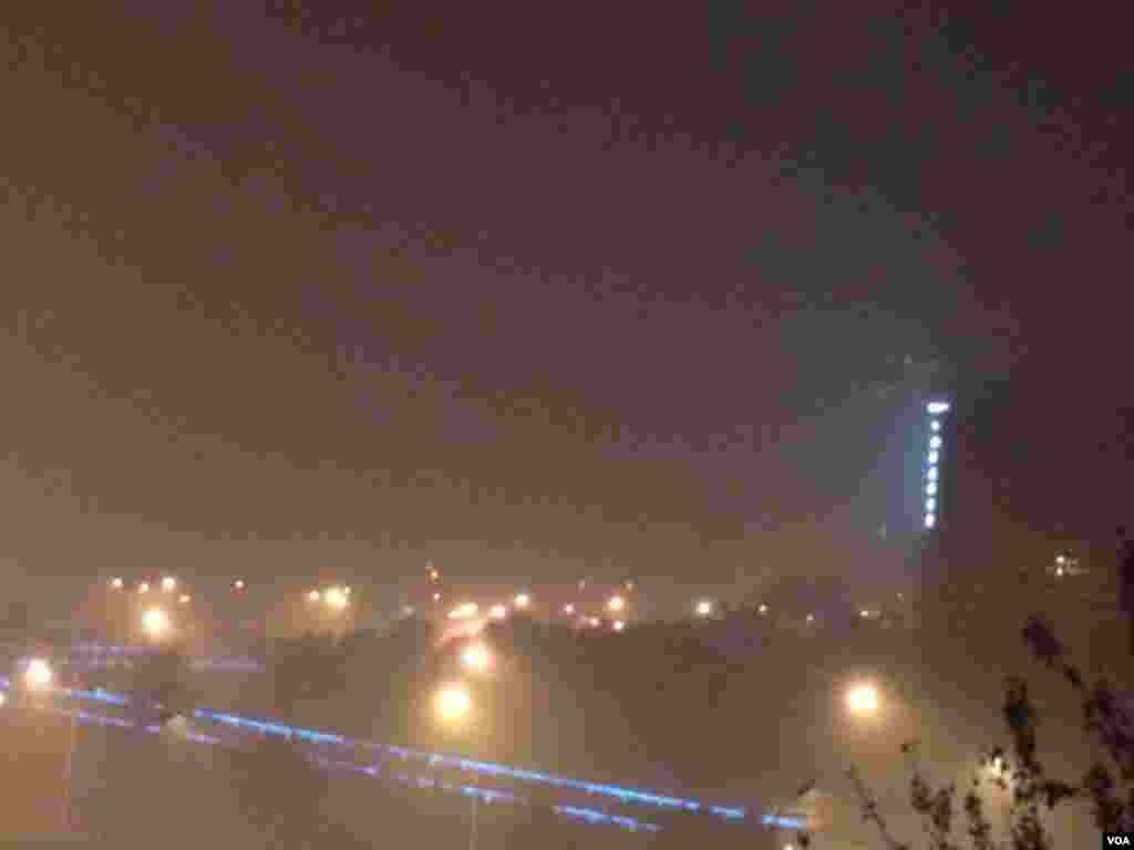 2015年11月30日，夜幕下的北京东长安街上空，雾霾弥漫。人们被告诫注意防范呼吸道疾病，减少出行。（美国之音叶兵拍摄）