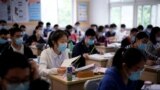 Students wearing face masks are seen inside a classroom during a government-organised media tour at a high school as more students returned to campus following the coronavirus disease (COVID-19) outbreak, in Shanghai, China May 7, 2020. REUTERS/Aly Song