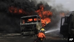 Firefighters try to contain a fire at an informal diesel fuel depot in Lagos, Nigeria on Thursday, Feb. 16, 2012.