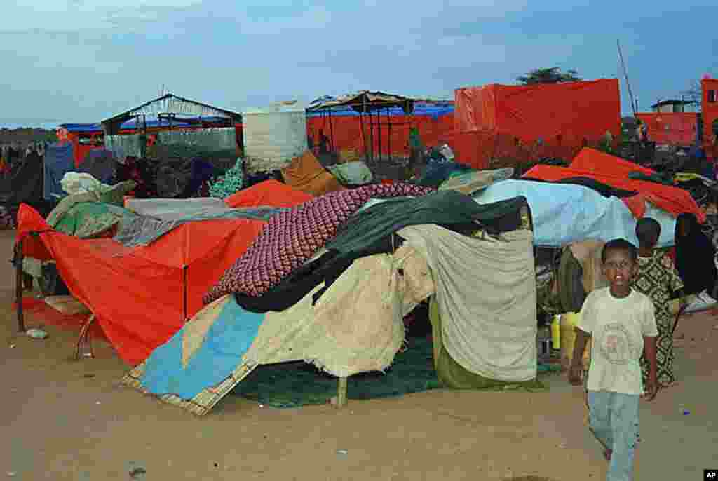 A boy walks by a makeshift shelter for new arrivals at the Dollo Ado refugee transit center in Ethiopia, October 26, 2011. (VOA - P. Heinlein)