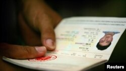 A Solomon Islander of Chinese descent holds his passport 