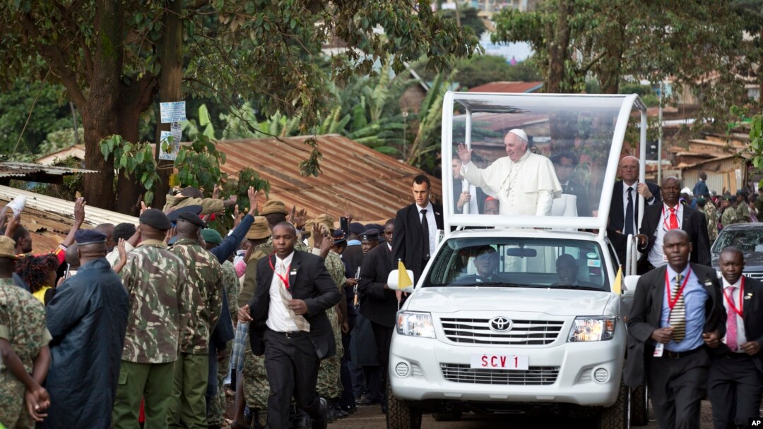 Paus Fransiskus melambaikan tangan kepada warga setempat saat berkendara dengan 'popemobile'-nya menuju gereja Katolik "Santo Joseph The Worker" di wilayah Kangemi, Nairobi, Kenya (27/11).
