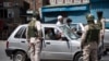 A Kashmiri man asks for permission to proceed in his car to buy medicines, during curfew in Srinagar, in Indian-controlled Kashmir, Aug. 4, 2020. 