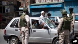 A Kashmiri man asks for permission to proceed in his car to buy medicines, during curfew in Srinagar, in Indian-controlled Kashmir, Aug. 4, 2020. 