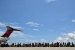 Abaco residents are evacuated from the island at the airport in the wake of Hurricane Dorian in Marsh Harbour, Great Abaco, Bahamas, Sept. 8, 2019.