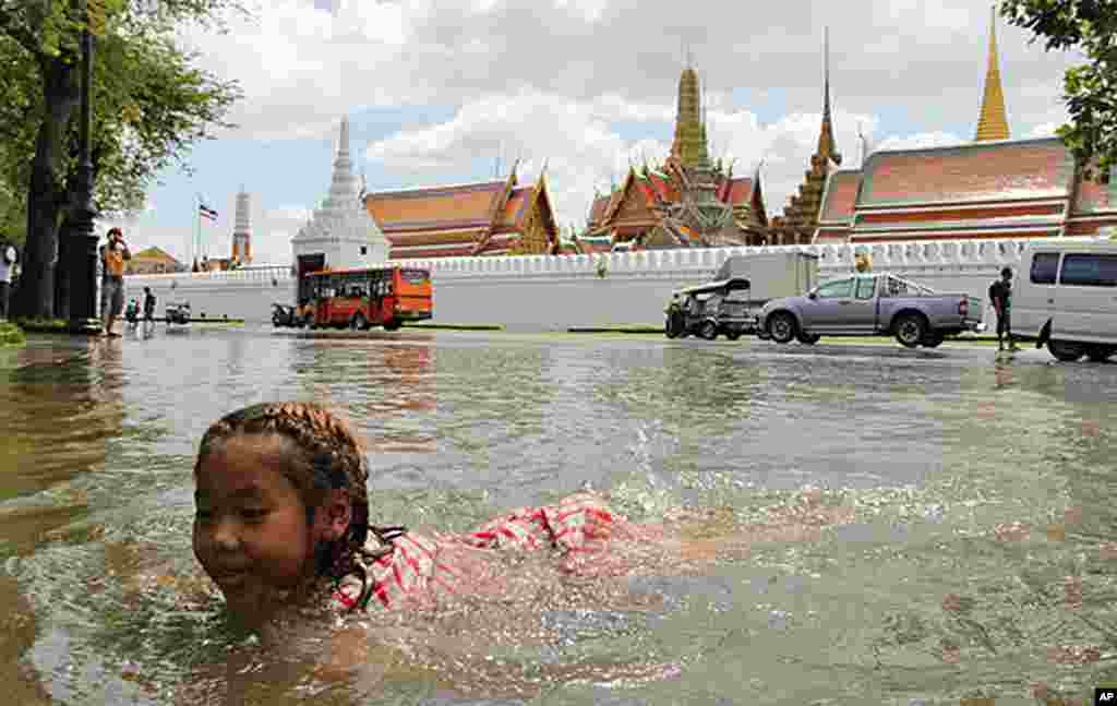 一名小女孩在曼谷大王宫前的大水中游泳嘻戏