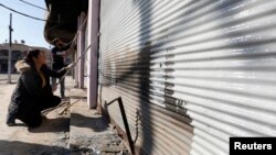 Iraqi volunteers paint over signs and writing of Islamic State militants, in Qaraqosh, Iraq, Feb. 7, 2017. 