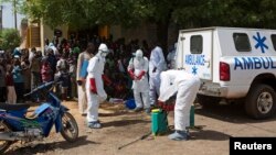 Health workers put on protective gear outside a mosque before disinfecting it, in Bamako, Mali, Nov. 14, 2014.