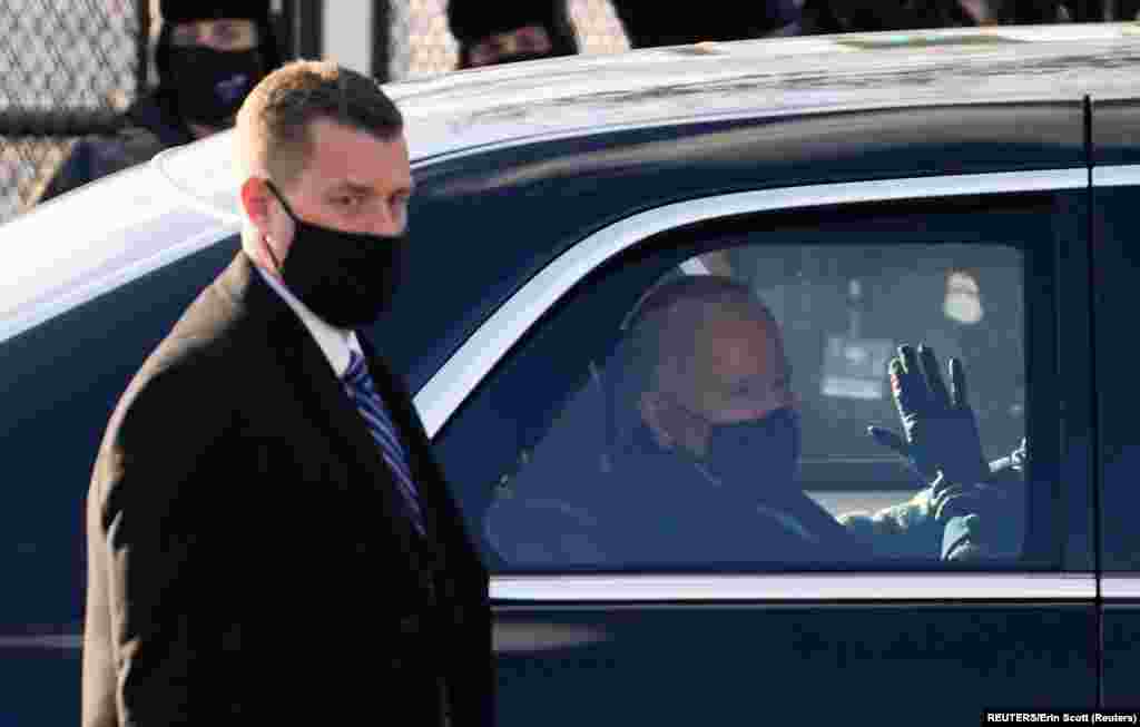 U.S. President Joe Biden waves through the window of a car during the Inauguration Day parade