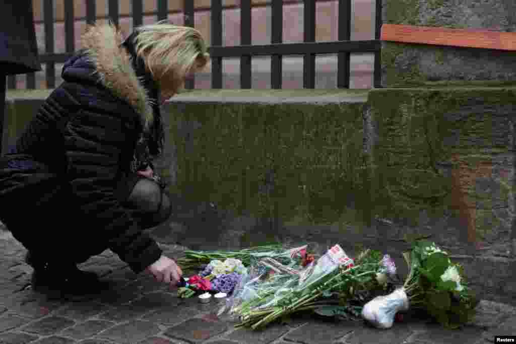 A woman lights a candle in front of the synagogue in Krystalgade in Copenhagen, Feb. 15, 2015. 