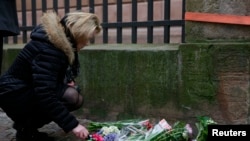 Seorang perempuan menyalakan lilin di depan synagog di Krystalgade di Copenhagen, 15 Februari 2015. 