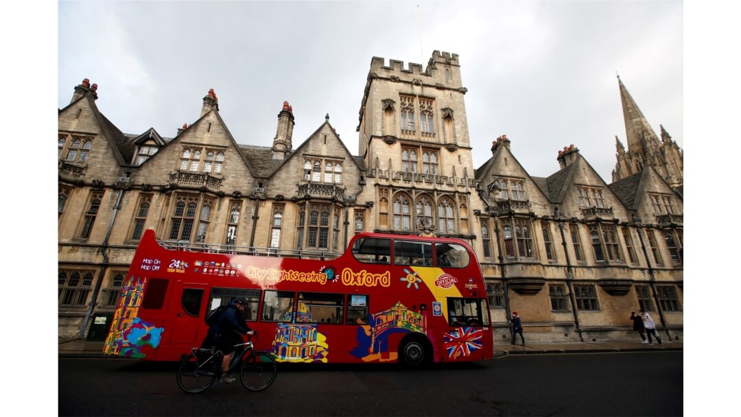 Bus wisata melewati gedung Universitas Oxford, di tengah penyebaran COVID-19, di Oxford, Inggris, 6 Oktober 2020. (Foto: Reuters)