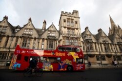 Bus wisata melewati gedung Universitas Oxford, di tengah penyebaran COVID-19, di Oxford, Inggris, 6 Oktober 2020. (Foto: Reuters)