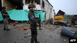 Police stand guard outside the Morales police station after militants opened fire and detonated cylinder bombs on it and a bank in the town of Morales, Cauca department, Colombia, on May 20, 2024.