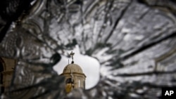 A church dome seen through a broken window of the Sednaya Convent, which was damaged by artillery fire in Sednaya, north of Damascus, Syria. Christians, who make up about 10 percent of Syria's population of more than 22 million, say they are particularly vulnerable to the violence that has been sweeping the country since March 2011.