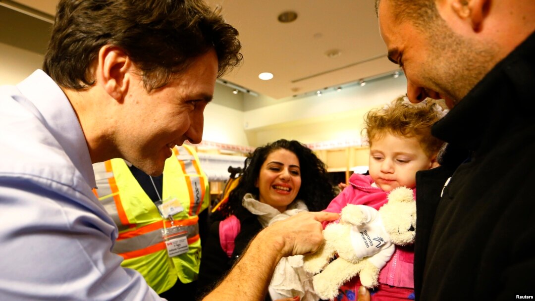 PM Kanada Justin Trudeau (kiri) menyambut langsung kedatangan rombongan pertama pengungsi Suriah di kota Toronto, Kamis malam (10/12). Kanada telah menyatakan kesediaan menampung 25.000 pengungsi Suriah sebelum akhir Februari 2016. 