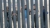 Члени каравану біженців із Гондурасу біля паркана на стіні кордону США-Мексика в Каліфорнії, 18 листопада 2018 року.