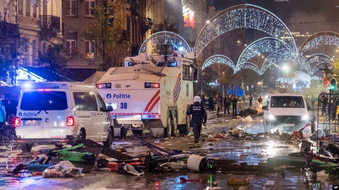 Mobil polisi melewati jalan raya utama di Brussel, Minggu, 27 November 2022, saat kekerasan pecah setelah kemenangan Maroko 2-0 atas Belgia di Piala Dunia. (Foto: AP)