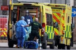 Medics transport a patient from an ambulance to the Royal London Hospital as the spread of the coronavirus disease (COVID-19) continues in London, Britain, Jan. 1, 2021.