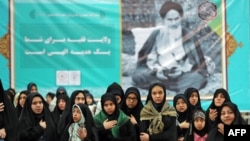 Iranian women pray in front of a a poster of Iran's late founder of the Islamic Republic, Ayatollah Ruhollah Khomeini, on the occasion of 40th anniversary of Khomeini's return from exile from Paris at his mausoleum in southern Tehran, Feb. 01, 2019. 