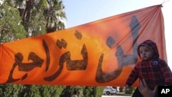 A child lifted beside banner that reads "never go back" at anti-Assad demonstration, Deir Balaba, near Homs, Nov. 27, 2011.