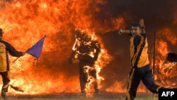 Daredevil motorcycle rider Captain Shivam Singh (C) from the &#39;Tornadoes&#39; motorcycle acrobatic team of the Indian Armed Forces comes out ablaze after catching fire while riding his bike through a tunnel of fire during an attempt to break the Guinness Book&nbsp;in Bangalore.