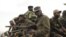 M23 rebels sit at the back of a pick-up truck captured a week before and formerly used by the Armed Forces of the Democratic Republic of Congo, as they carry supplies through Bunagana, July 15, 2012. 