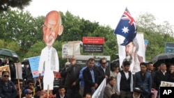 Protesters with a cutout of Afghan President Ashraf Ghani demonstrate against his visit to Australia outside Government House where Ghani met with Governor-General Peter Cosgrove, in Canberra, April 3, 2017. 