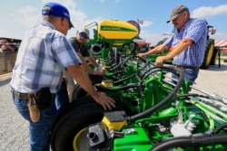 Visitors to the Husker Harvest Days farm show in Grand Island, Neb., look over John Deere equipment, Sept. 10, 2019.