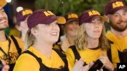 FILE - Arizona State University and University of Arizona fans engage in friendly competition ahead of the annual rivalry game, Nov. 30, 2019, in Tempe, Arizona.