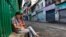 Day laborers wearing masks to protect against the coronavirus wait for work on a street in Dharmsala, India, Sept. 23, 2020.