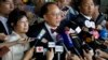 FILE - Donald Tsang, center, former leader of Hong Kong talks to reporters with his wife Selina as they leave a magistrate's court in Hong Kong, Oct. 5, 2015. Tsang faces misconduct charges over a luxury apartment rental in mainland China.