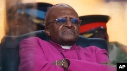 Mantan uskup agung Afrika Selatan Desmond Tutu menunggu giliran berbicara dalam upacara penghormatan untuk mantan presiden Nelson Mandela di Soweto (10/12). (AP/Matt Dunham)