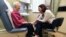In this March 4, 2019 photo, Dr. Allison Magnuson, left, speaks with patient Nancy Simpson at the Pluta Cancer Center in Rochester, N.Y.