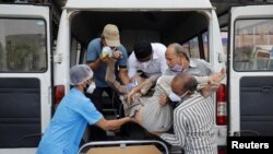 Healthcare workers and relatives carry Shashikantbhai Parekh, a patient with breathing problem, out from an ambulance for treatment at a COVID-19 hospital, amidst the spread of the coronavirus disease (COVID-19) in Ahmedabad, India, Apr. 28, 2021.