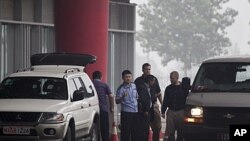 Canadian officials, center right, talk with Chinese counterparts as they arrive in Beijing's Capital International Airport in Beijing, China, July 23, 2011. Chinese fugitive Lai Changxing arrived in China after a 12-year extradition court battle in Canada
