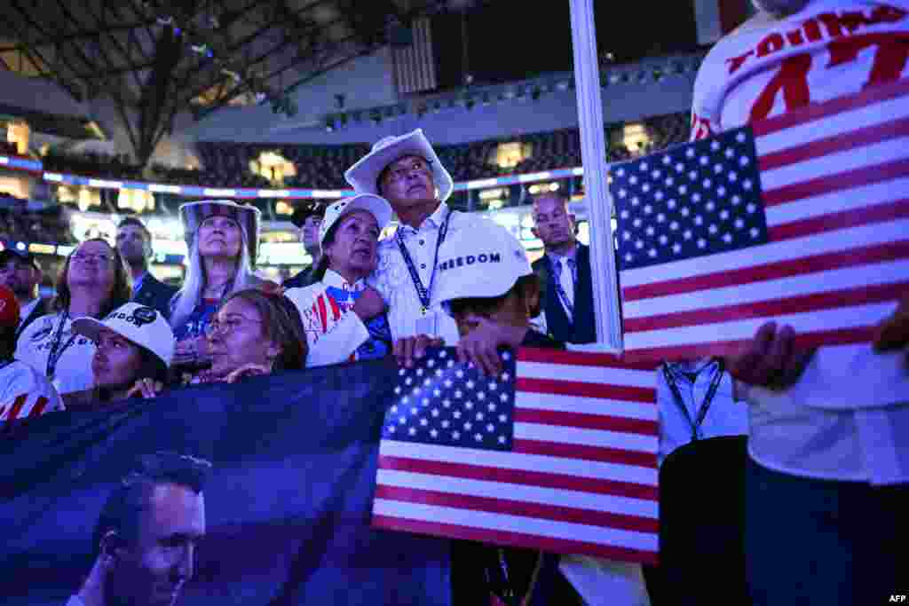 Attendees watch a video showing slain activist Charlie Kirk, on the first anniversary of Kirk's assassination, as it plays on screens during the second day of the Republican National Committee midterm convention at the American Airlines Center in Dallas, Texas on September 10, 2026.