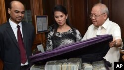 This photo provided by the Bangko Sentral ng Pilipinas, from left, Second Secretary and Head of Chancery of the Bangladesh Embassy in Manila Probash Lamarong, Anti-Money Laundering Council (AMLC) Secretariat Executive Director Julia Bacay-Abad