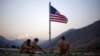 FILE - In this Sept. 11, 2011 photo, US soldiers sit beneath an American flag just raised to commemorate the tenth anniversary of the 9/11 attacks at Forward Operating Base Bostick in Kunar province, Afghanistan. 