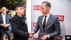 German Foreign Minister Heiko Maas, right, and Hong Kong activist Joshua Wong shake hands during a reception for German newspaper Bild, in Berlin, Germany, Sept. 9, 2019.