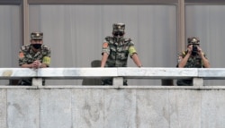 North Korean soldiers keep watch toward the south as South Korean Unification Minister Lee In-young inspects the truce village of Panmunjom, Sep. 24, 2020.