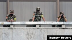 North Korean soldiers keep watch toward the south as South Korean Unification Minister Lee In-young inspects the truce village of Panmunjom