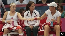 Bethanie Mattek-Sands, left, of the United States touches hands with doubles partner Liezel Huber as they talk with coach Mary Joe Fernandez during their doubles match against Russia in their Fed Cup tennis match in Birmingham, Ala., 25 Apr 2010 (file pho