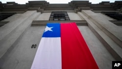 La entrada este del palacio presidencial de La Moneda se muestra cubierta con una bandera chilena durante un evento que conmemora la victoria presidencial del difunto Salvador Allende en 1970 en Santiago, Chile, el lunes 4 de septiembre de 2023.