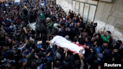 Mourners and Palestinian Hamas members carry the body of their comrade, who was killed in an Israeli airstrike, during his funeral in Gaza City December 9, 2017. 