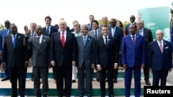 De gauche à droite : le président kenyan Uhuru Kenyatta, le président guinéen Alpha Condé, le président américain Donald Trump, le Premier ministre italien Paolo Gentiloni, le président français Emmanuel Macron, le président nigérien Mahamadou Issoufou et le président tunisien Beji Caid Essebsi posent pour une photo de famille avec d'autres participants de le sommet du G7 lors du Sommet des chefs d'État et de gouvernement du G7, à Taormina, en Sicile, en Italie, le 27 mai 2017