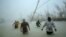 Voluntarios caminan bajo el viento y la lluvia del huracán Dorian en Freeport, Grand Bahama, Bahamas, el martes, 3 de septiembre de 2019.