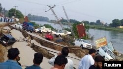 Warga berkumpul di sekitar jalanan yang rusak akibat gempa bumi berkekuatan 5.8 di Mirpur, Pakistan, 24 September 2019. 