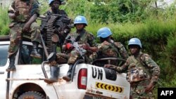 Des casques bleus de la Mission de l'Organisation des Nations Unies pour la stabilisation en République démocratique du Congo MONUSCO assis à l'arrière d'un camion pick-up de l'ONU, à Beni, 23 octobre 2014. 